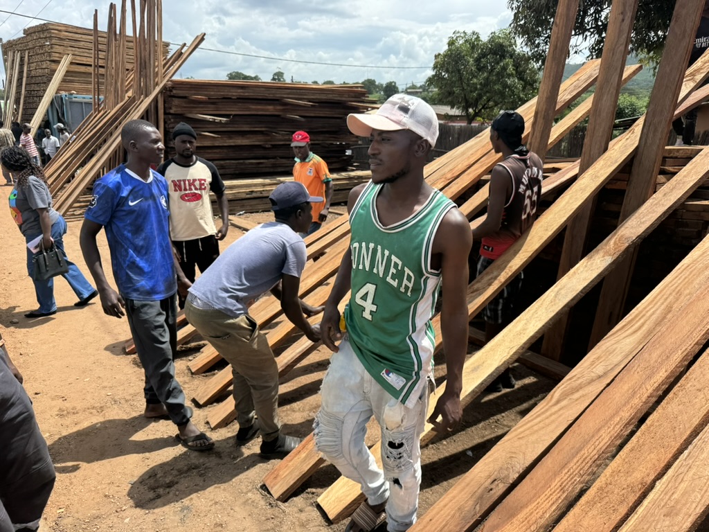 23-Januari 2026: Vandaag kopen we de materialen voor een open beschutting voor ons voedselprogramma. Als het regent is er geen plek waar moeders en kinderen kunnen schuilen. Shema (hij neemt de verantwoording voor onze lokale tuin) had al wel iets gemaakt maar dat was alleen een tijdelijke beschutting. Op de foto worden de planken die we gekocht hebben apart gelegd