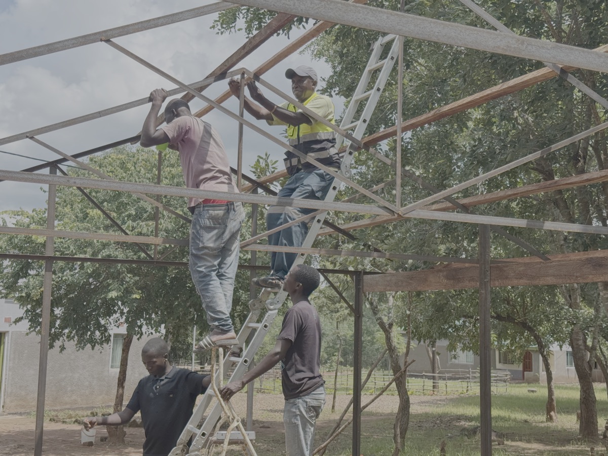 Verder werken aan de open beschutting. Tijdens de constructie van de raamwerken hebben we de gaten voor de bevestiging van de houten latten al voorgeboord. Toch is het nog een behoorlijk lastig karwei.